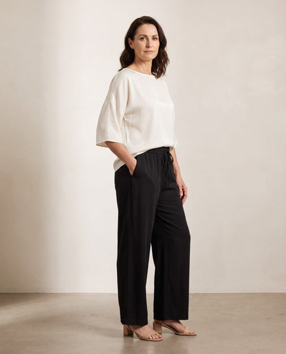 Oktavija Kate Top in ivory styled with black wide-leg trousers, shown on a digitally generated model
