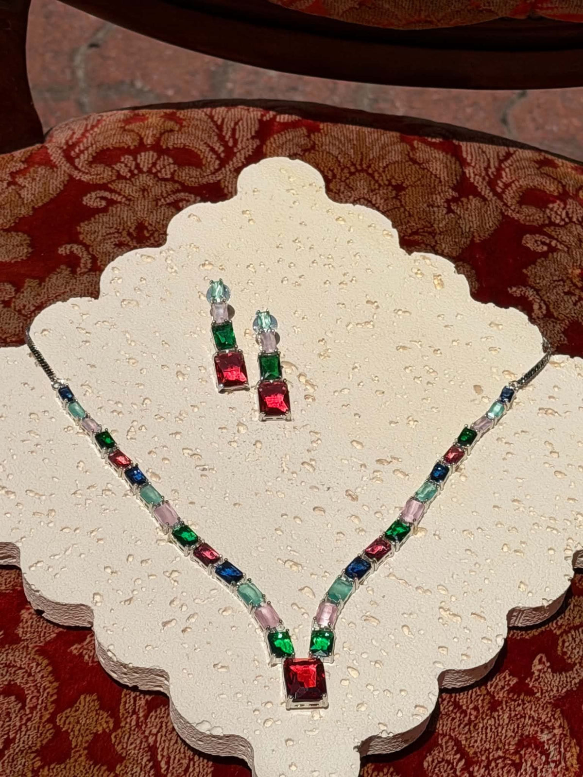 Emerald and ruby crystal necklace and drop earrings on display
