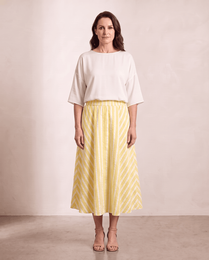 Willow Skirt in yellow stripe styled with an ivory top, shown on a digitally generated model
