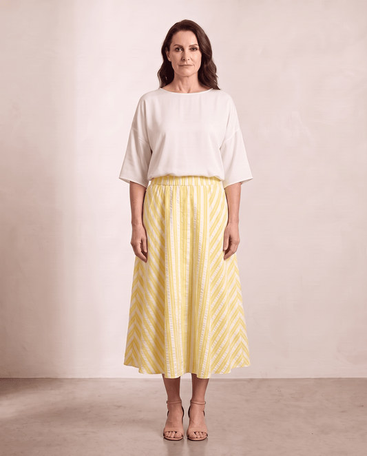 Willow Skirt in yellow stripe styled with an ivory top, shown on a digitally generated model